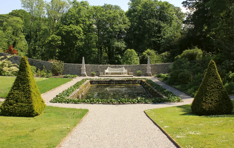 The formal walled garden at Plas Cadnant, a long lily pool between clipped yews with a stone seat at its head.