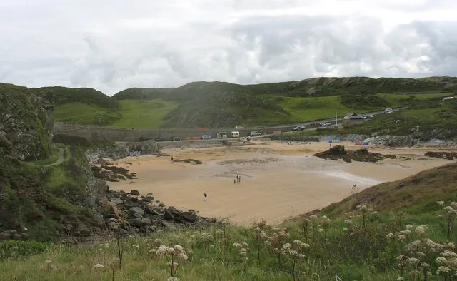 Porth Dafarch beach on Holy Island's west coast, framed by low rock headlands.