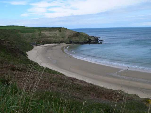 The pale sand and clear shallows of Porth Oer, a cove on the north coast of the Llŷn Peninsula, Gwynedd.
