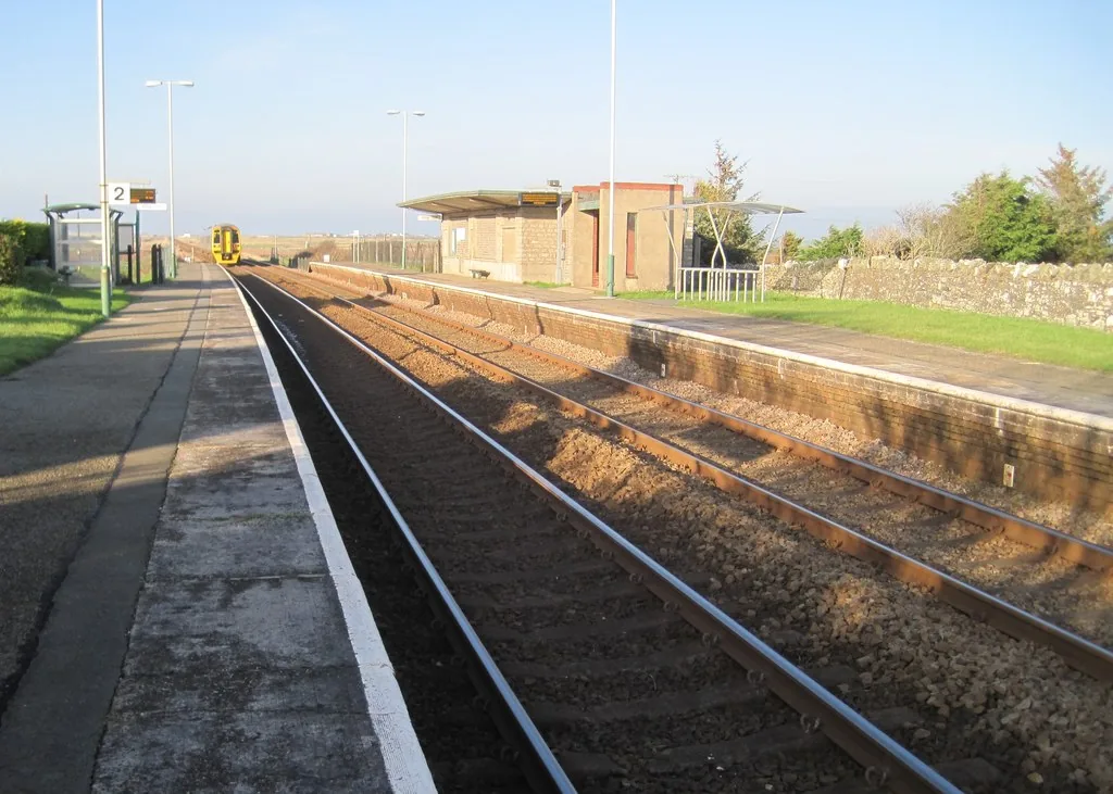 Rhosneigr railway station, a request-stop platform on the Anglesey line, with a train approaching