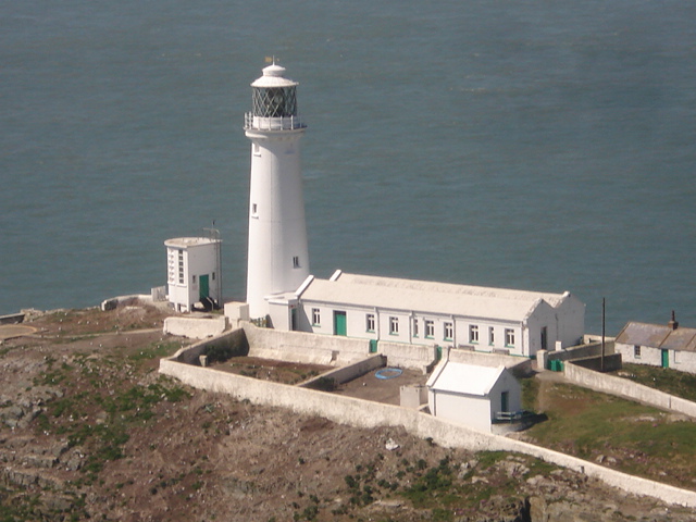 South Stack Lighthouse and its white keepers' quarters within the walled enclosure on the rock, the Irish Sea behind.