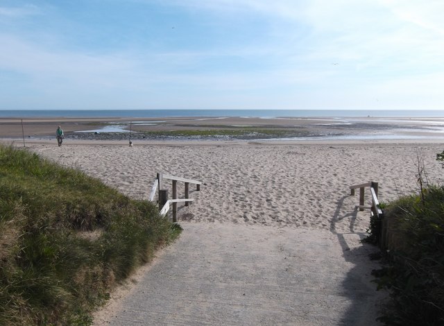 The wide sands and grassy access slope at Traeth Lligwy beach on Anglesey's east coast.