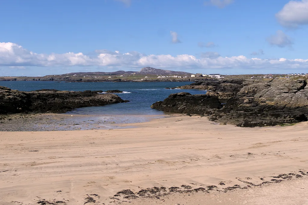 Porth Castell, a small sandy cove framed by dark rocks.