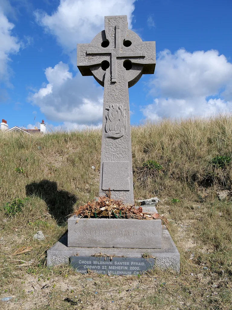 Saint Ffraid's Millennium Cross, a stone Celtic cross on the dunes above the beach.