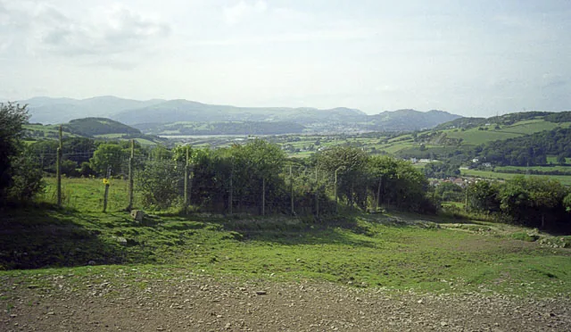 A view over rolling hills and mountains in the distance, seen from within the Welsh Mountain Zoo.