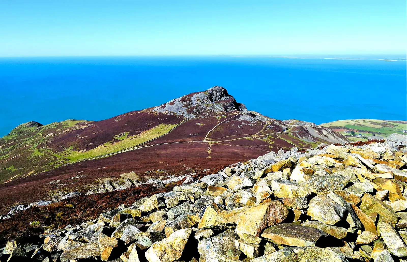 Garn Fôr seen from Garn Ganol, its quarried slopes dropping to the sea