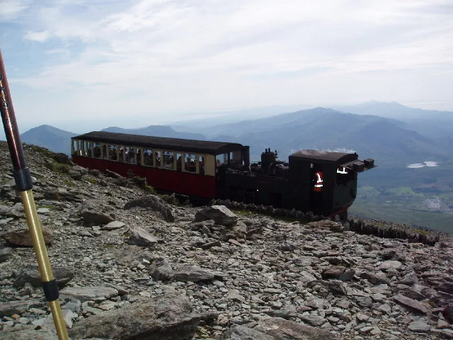 The Snowdon Mountain Railway train climbing near the summit, sea beyond